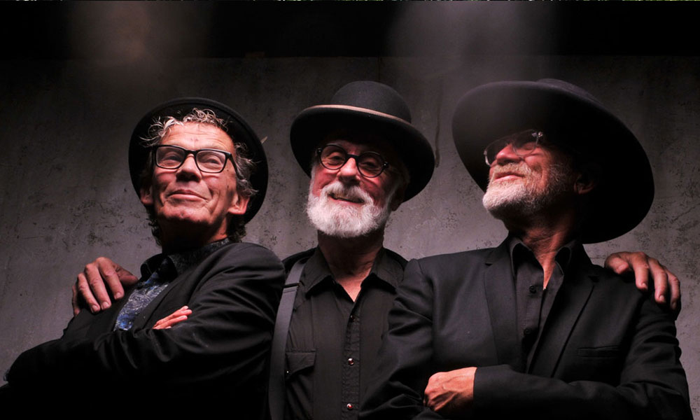 Drei angesehene Musiker - die Mojo Monkeys - David Raven (Singer Songwriter/ Schlagzeug, Lead Vocals), Taras Prodaniuk (Bass, Gesang) und Billy Watts (Gitarre, Gesang).